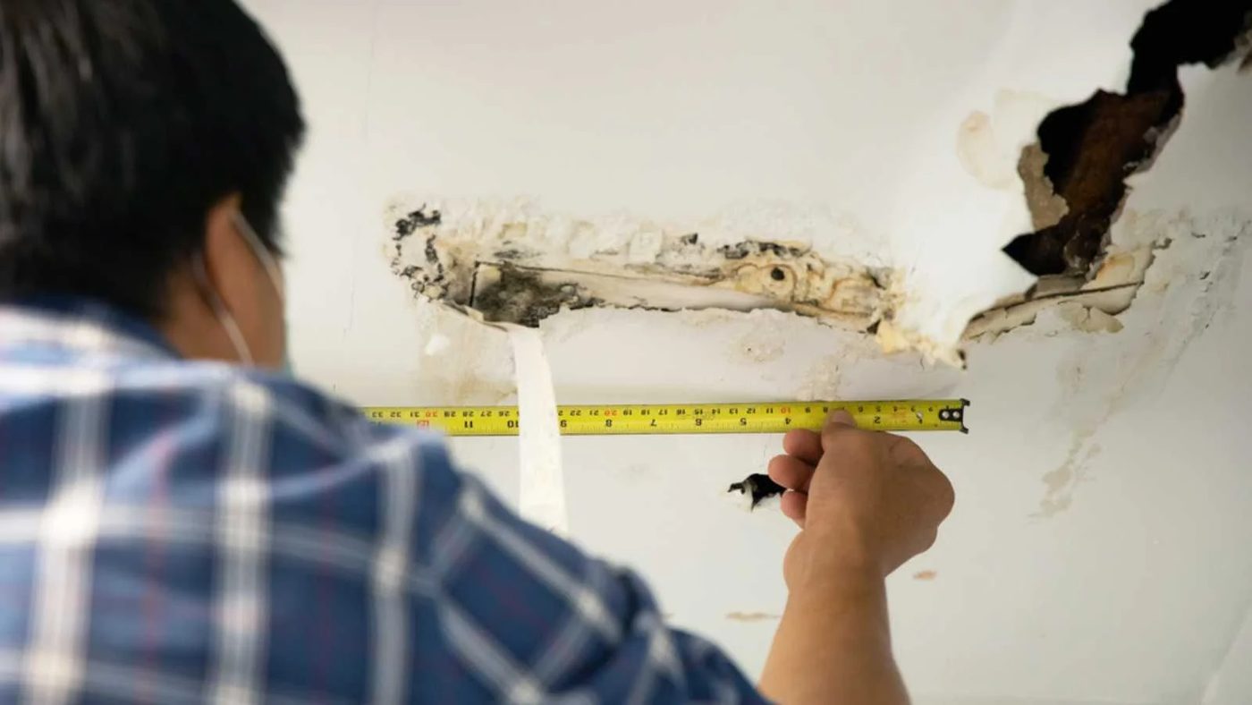 Ceiling house broken from pipes water leakage with worker repair and fixing ceiling panels. Office building or house problem from hole damaged pipeline leak by repairman service co