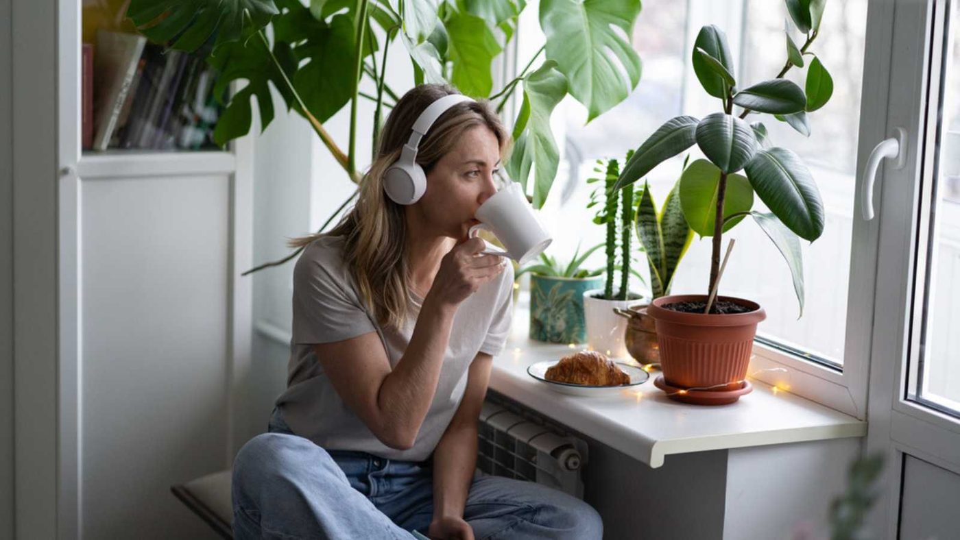 Woman Having Coffee Near Indoor Plants