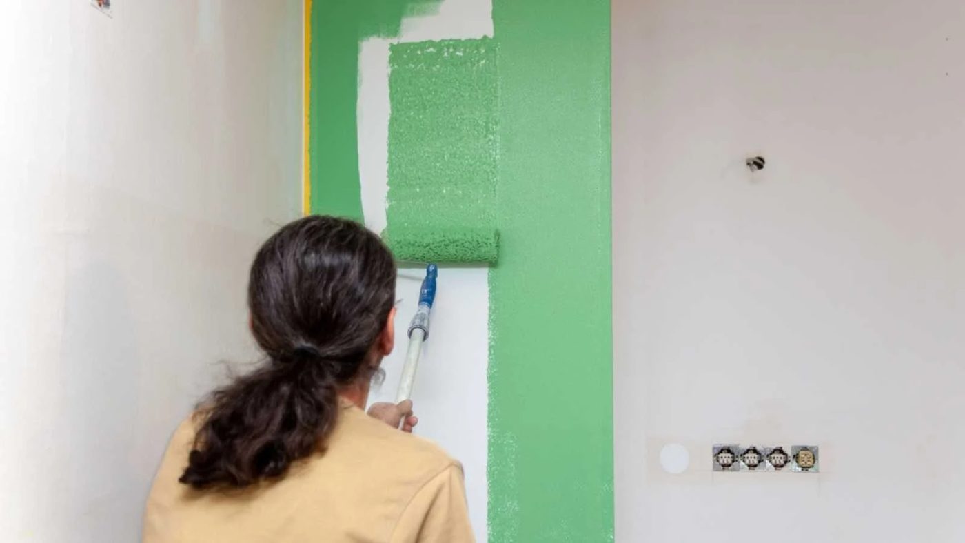 Renovation of a kitchen. Painter painting a wall.