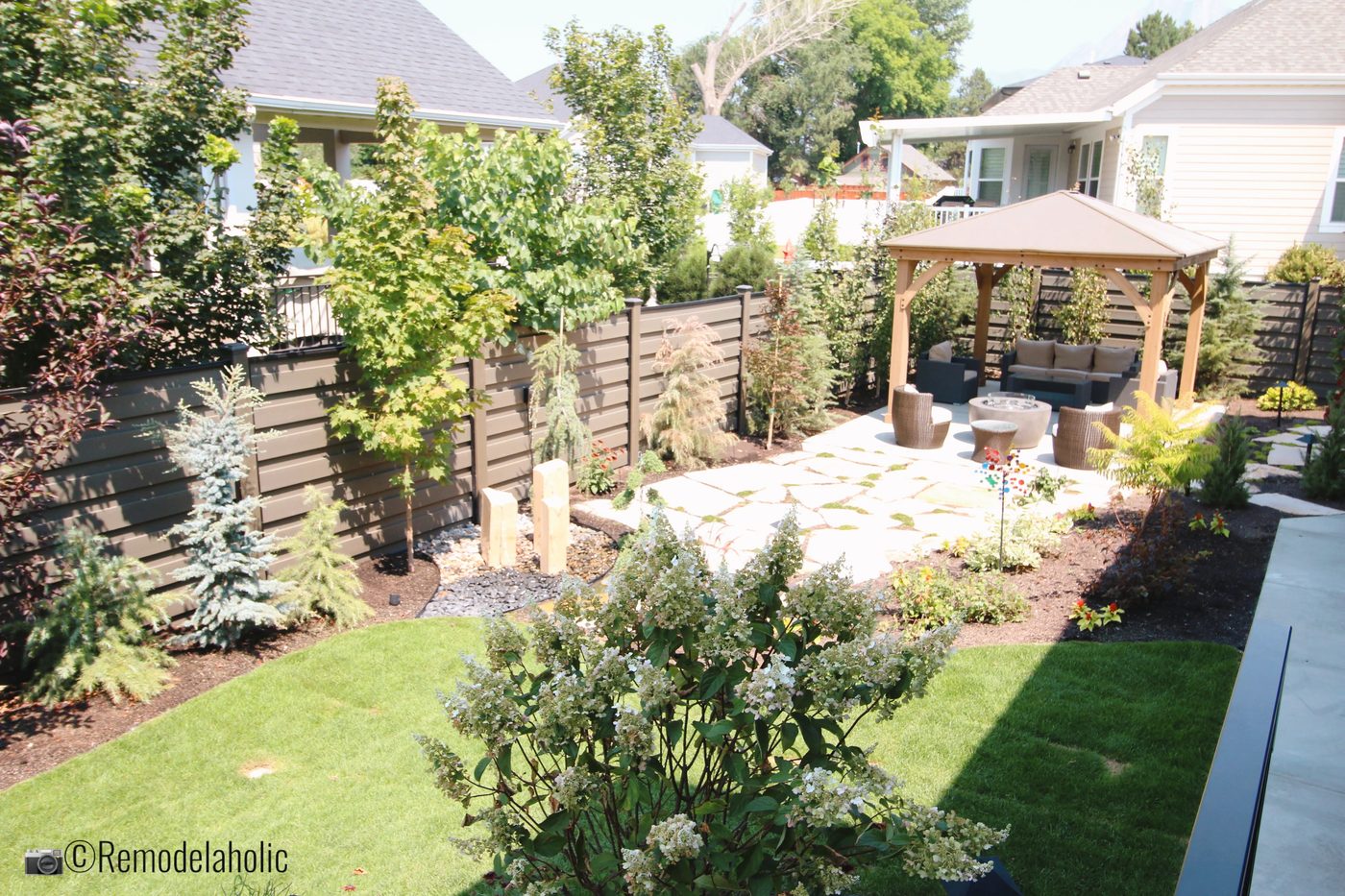 A shaded pergola area is well fitted in a vivid landscaped yard, SLPH 2018 Home 3 Breen Homes, Photo by Bekob