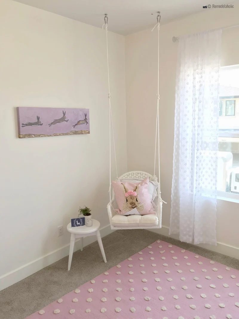 Little girls room with a wicker swinging chair, with a cute pink bunny pillow. SLPH 2018 Home 5 Regal Homes, photo by Bekob.com