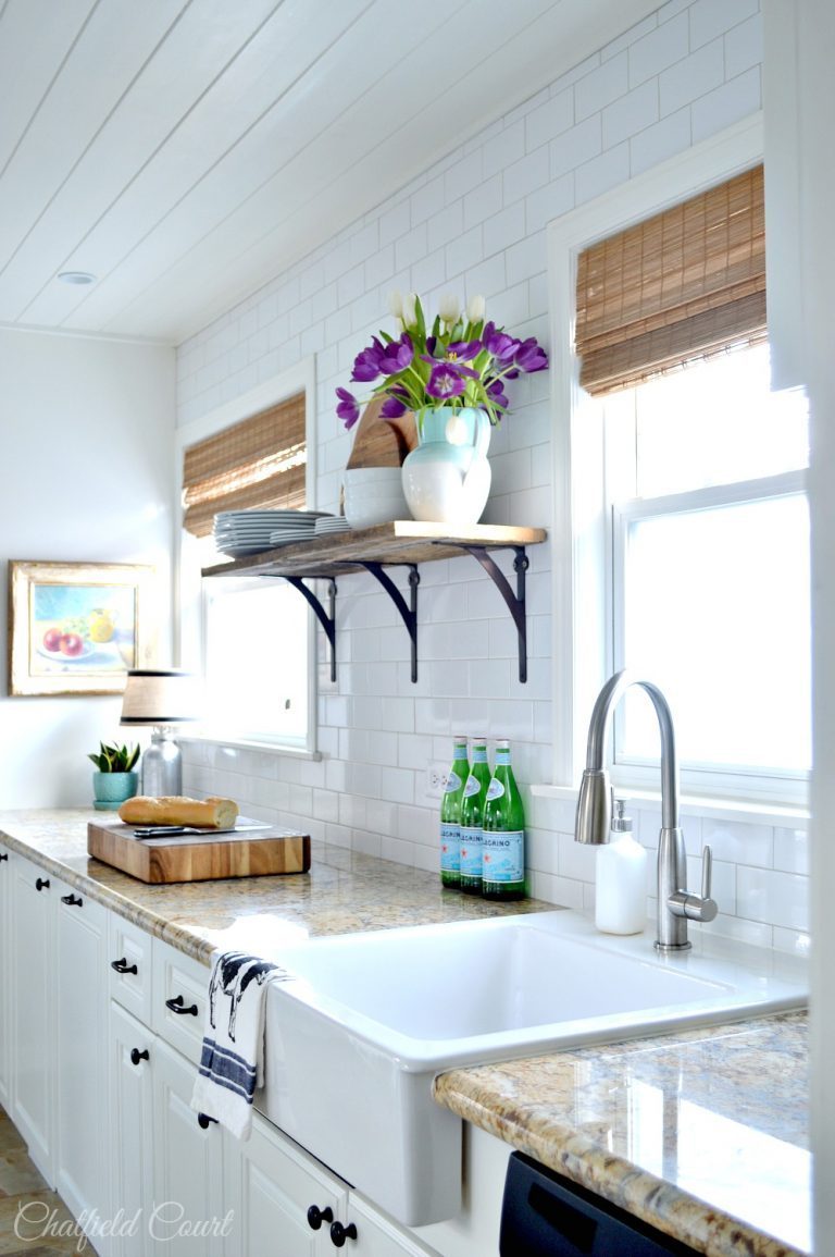 White Kitchen With Brown Accents And Custom Plank Ceiling