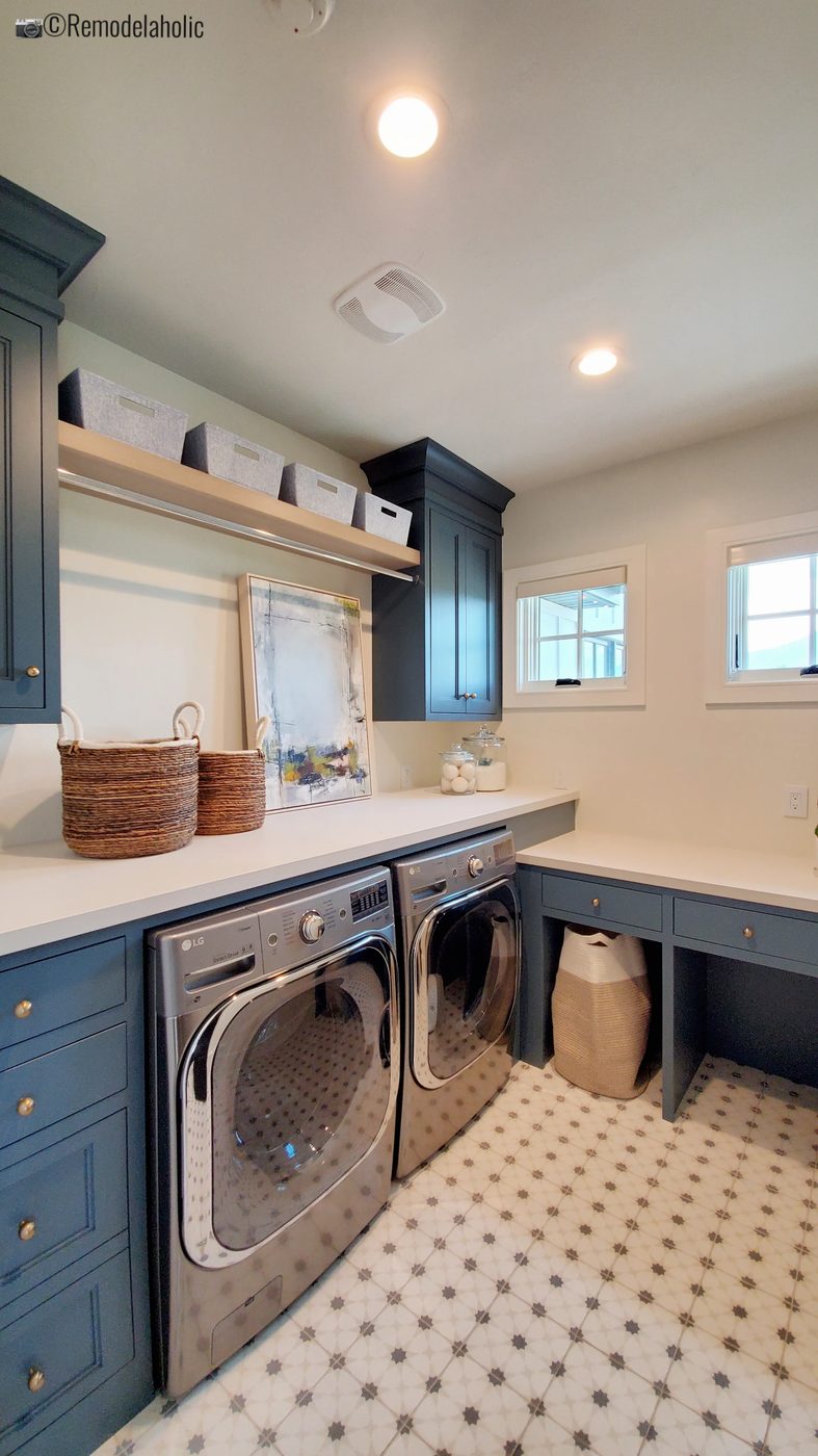 Patterned floor tile with blue cabinets laundry room. UVPH 2021 Home 01 Regent Custom Homes Designer Olsen Homes Interior Design, Photo by Bekob