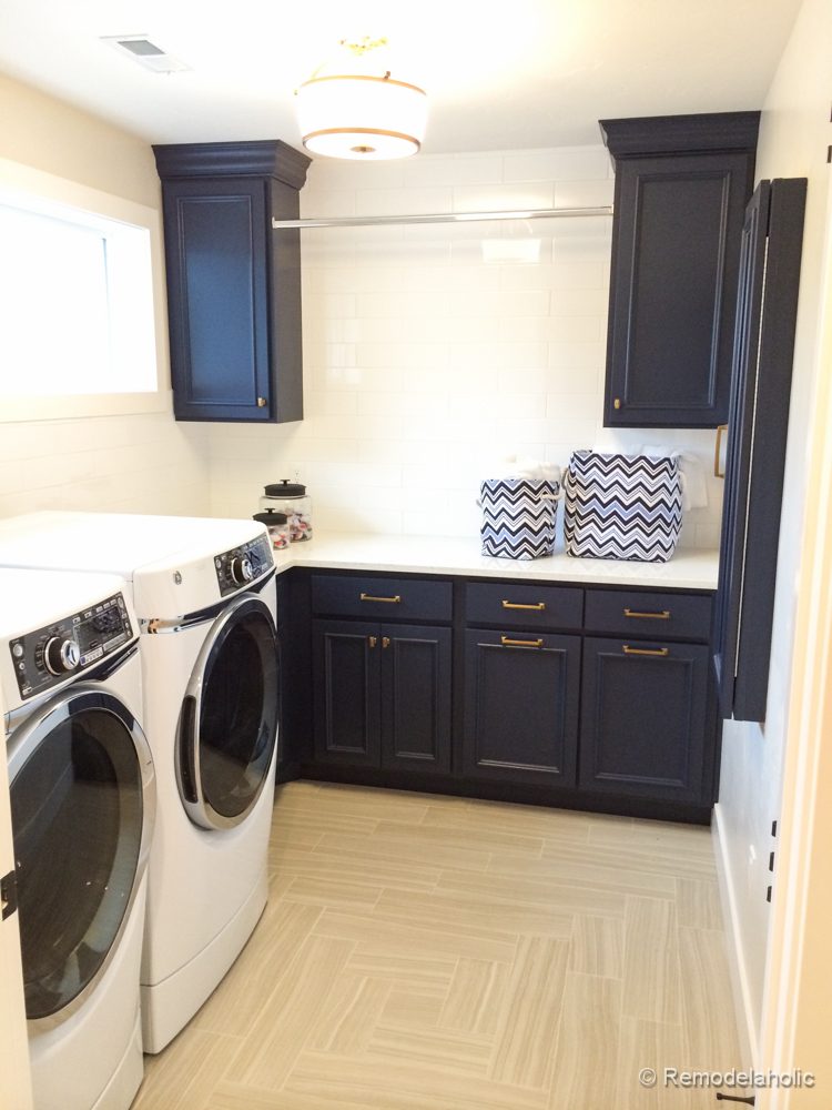 Tile floor pattern with pretty navy cabinets and hanging bar featured on Bekob.com