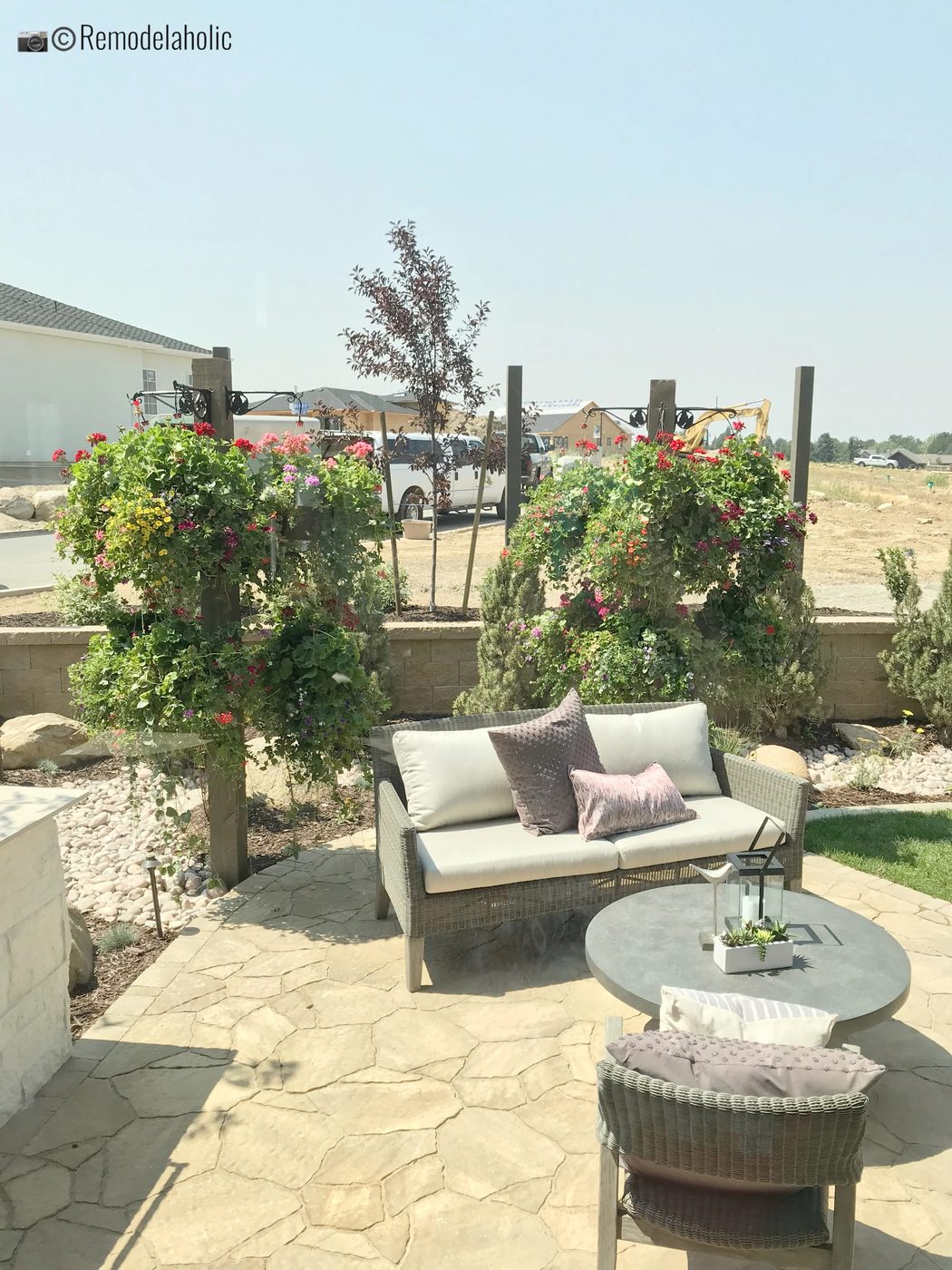 Patio area in the garden with a loveseat. SLPH 2018 Home 5 Regal Homes, Photo by Bekob