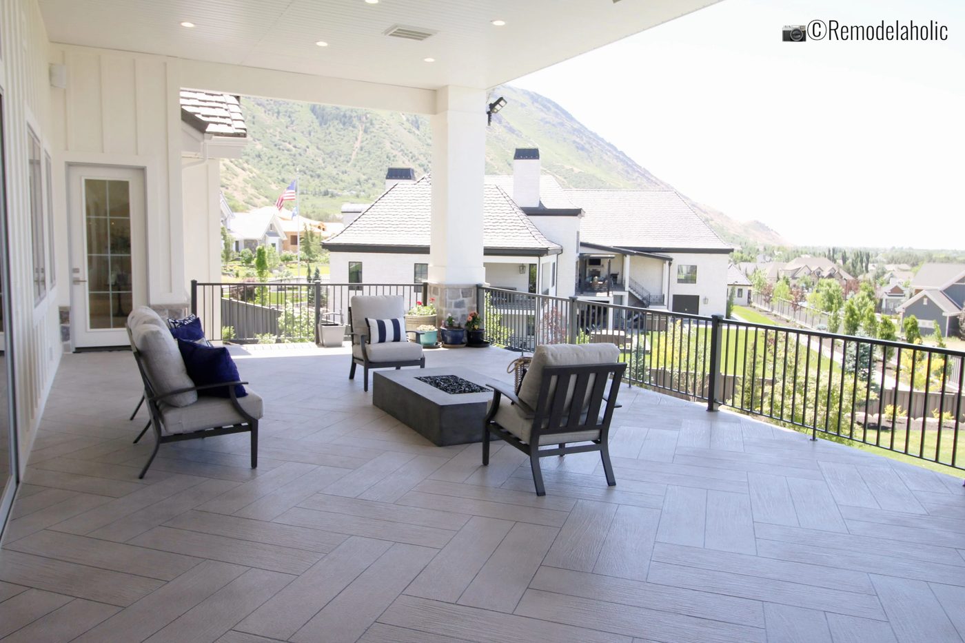 Metal Sofa on a covered patio with fire table. UVPH 2018 Home 33 E Builders, Erin Hansen Design, Photo by Bekob