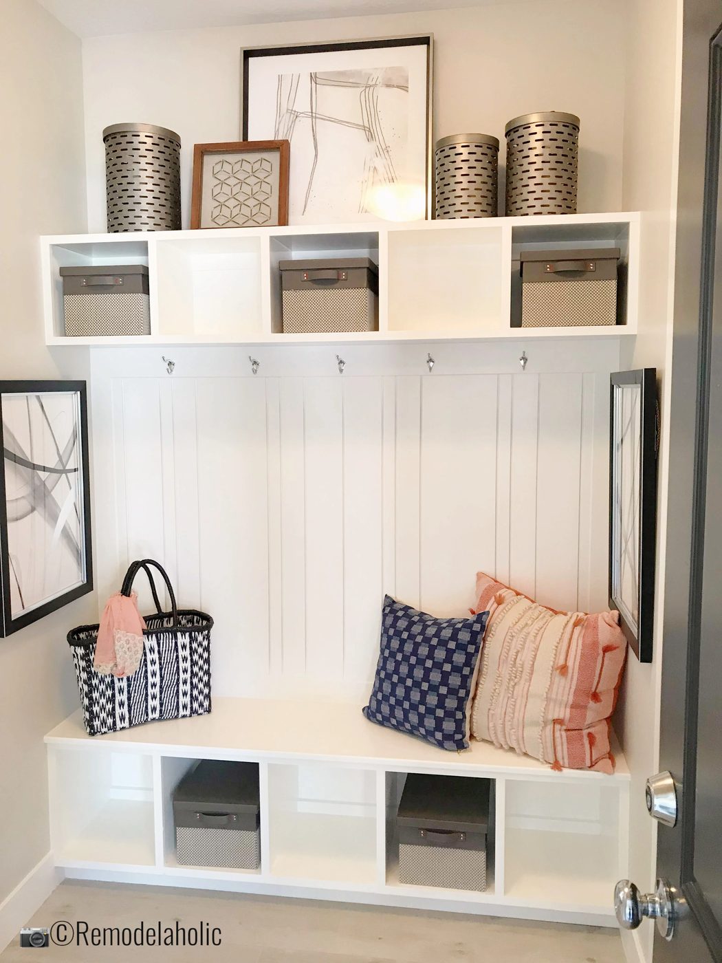 Adding artwork and pillows to a mudroom bench. UVPH 2018 Home 11 Concord Homes, Tailored Interior Design, Photo by Bekob
