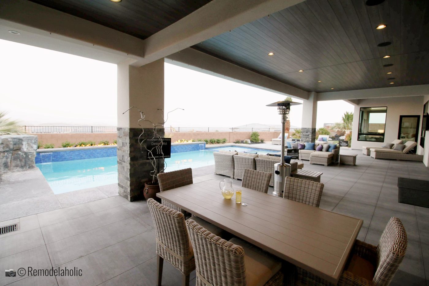 Neutral patio set near a pool. SGPH 2019 House 11 Anderson Custom Homes, Photo by Bekob