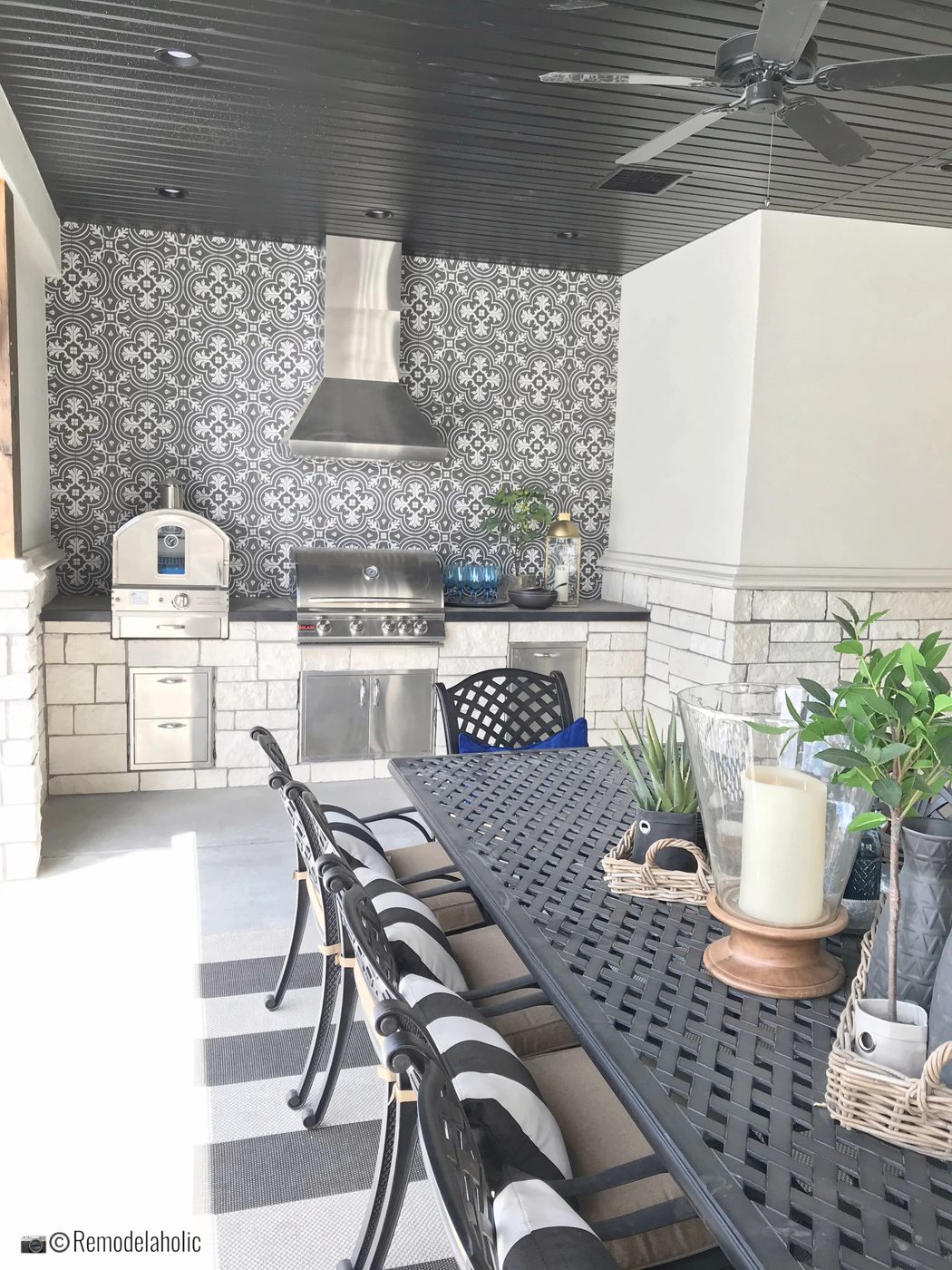 Outdoor kitchen area with dining table and cute pillows. UVPH 2018 Home 30 Shelby Homes, Gatehouse No. 1 Furniture & Design, Photo by Bekob