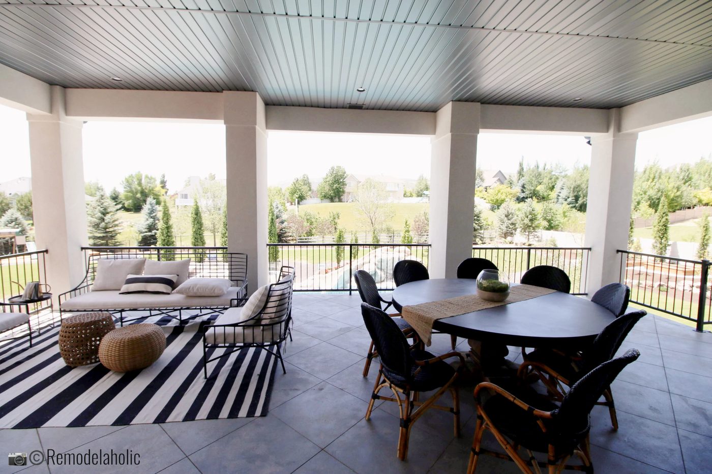 striking outdoor dining set on covered patio. UVPH 2018 Home 31 Raykon Construction, White + Gold Design, Photo by Bekob