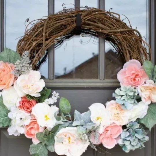 Grey Front Door With Twig Wrath And Pretty Pink And White And Blue Flowers With Green Leaves Throughout