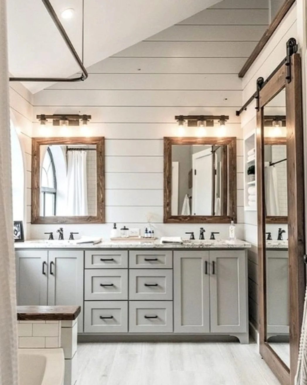 Shiplap Wall Of Bathroom With Colored Cabinets And Raw Wood Mirrors