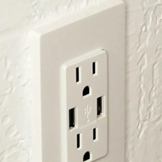 Two Outlets With USB Ports On Each Side, White Plated Against White Wall