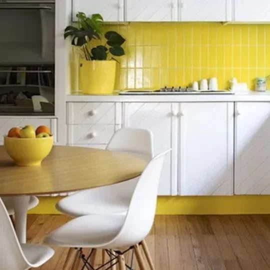 Kitchen With Yellow Walls And Trim, White Cupboards And Chairs, Wooden Table And Flooring