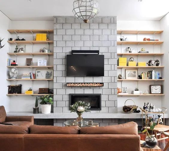 Love the rustic rough industrial look to this concrete fireplace with track shelving to the sides!