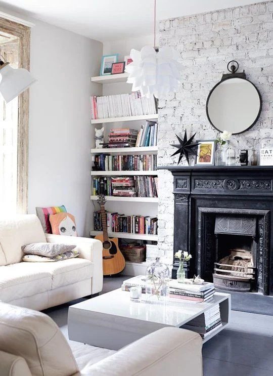 vivid black fireplace on a white wall with floating shelves