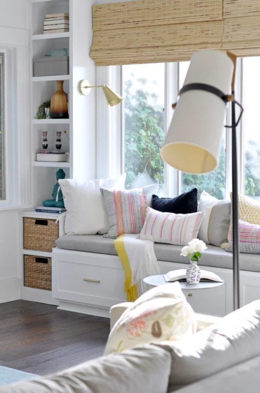 White And Grey Window Bench With Colorful Pillows And Wicker Baskets