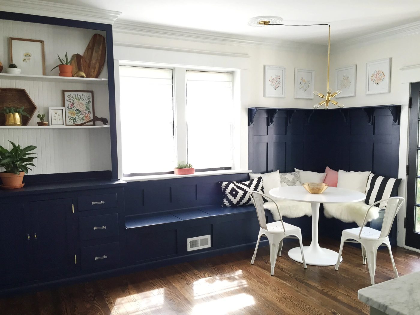 vivid navy dining room banquette plus built-in hutch. The paneled board and batten below the ledge is vivid above the banquette!