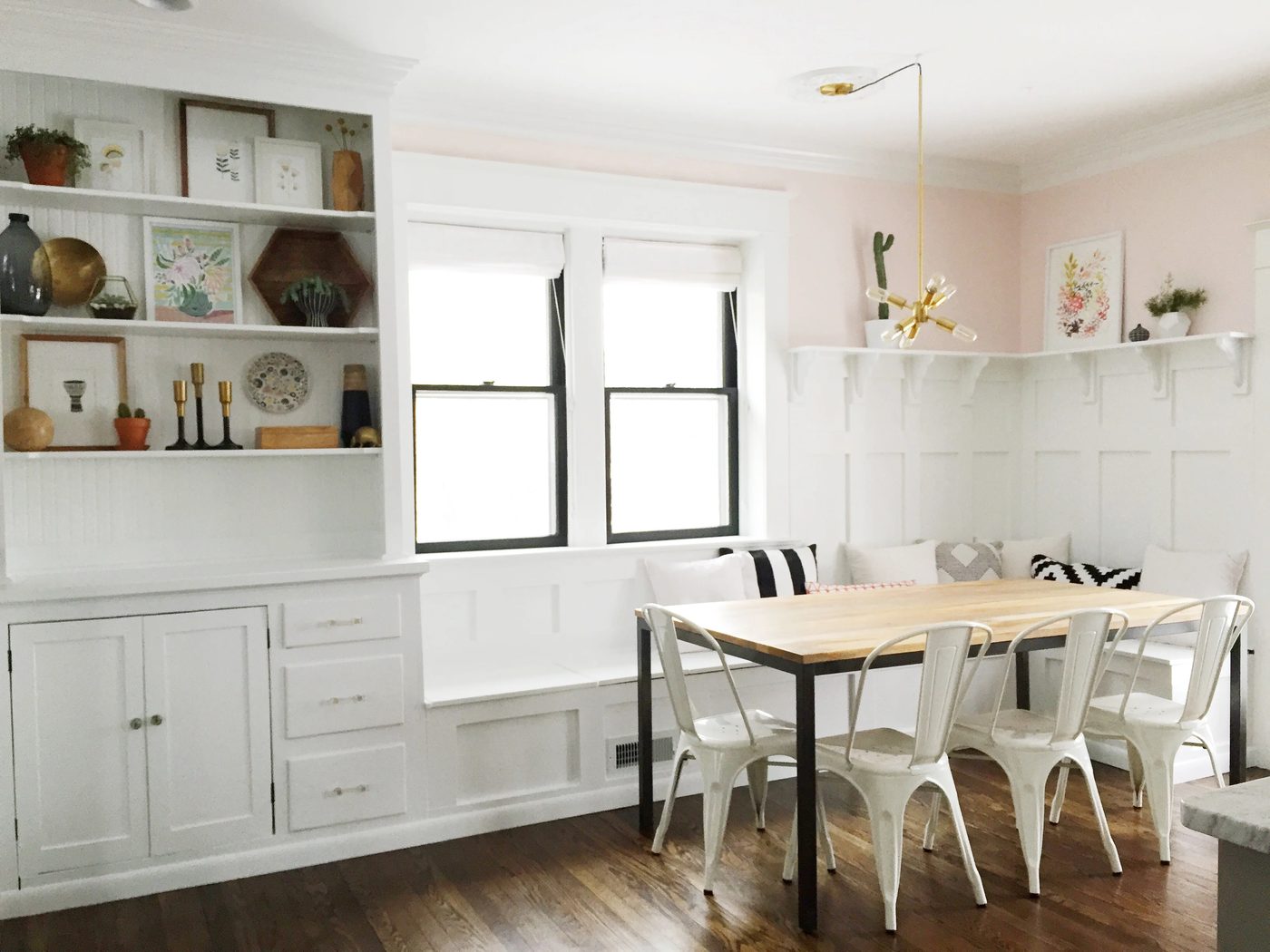 vivid pink and white dining room banquette plus built-in hutch. The paneled board and batten below the ledge is vivid above the banquette!