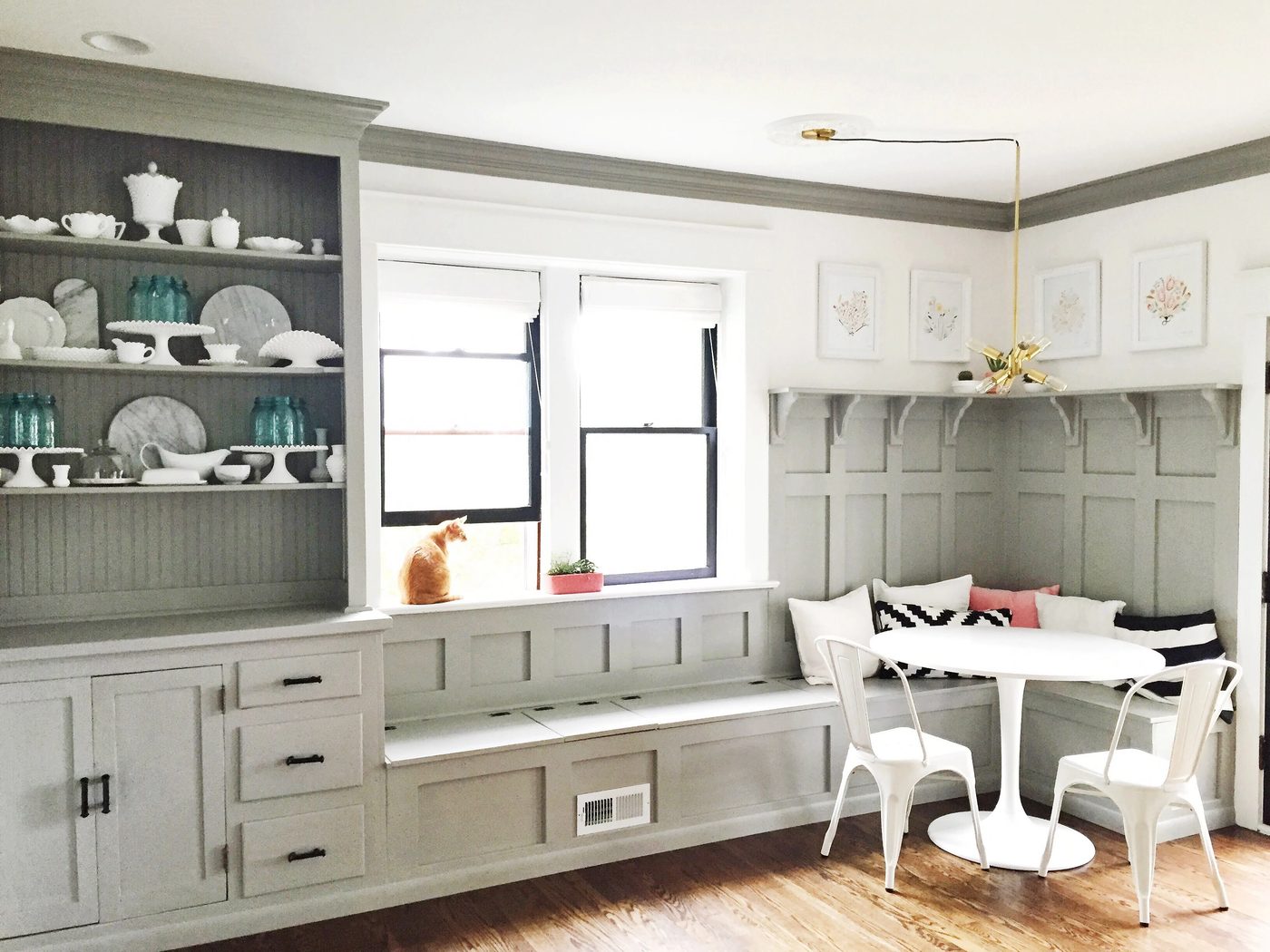 vivid gray dining room banquette plus built-in hutch. The paneled board and batten below the ledge is vivid above the banquette!