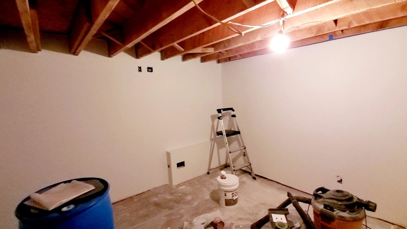 basement remodel - white painted walls with open ceiling beam joists