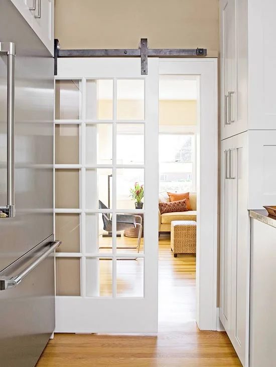 striking Doors - white french door with glass panes on barn style hardware via BHG
