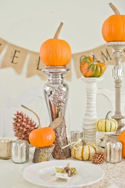 pumpkin centerpiece using tall candlesticks and cut logs and mercury glass Domestic Fashionista