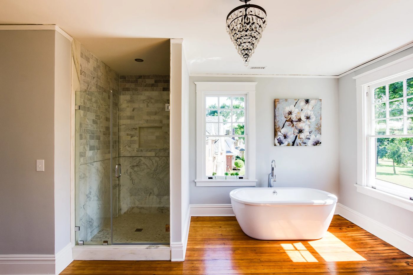 (Hawthorne) spacious open bathroom with wood floor, walk in marble shower, and white basin tub @Bekob