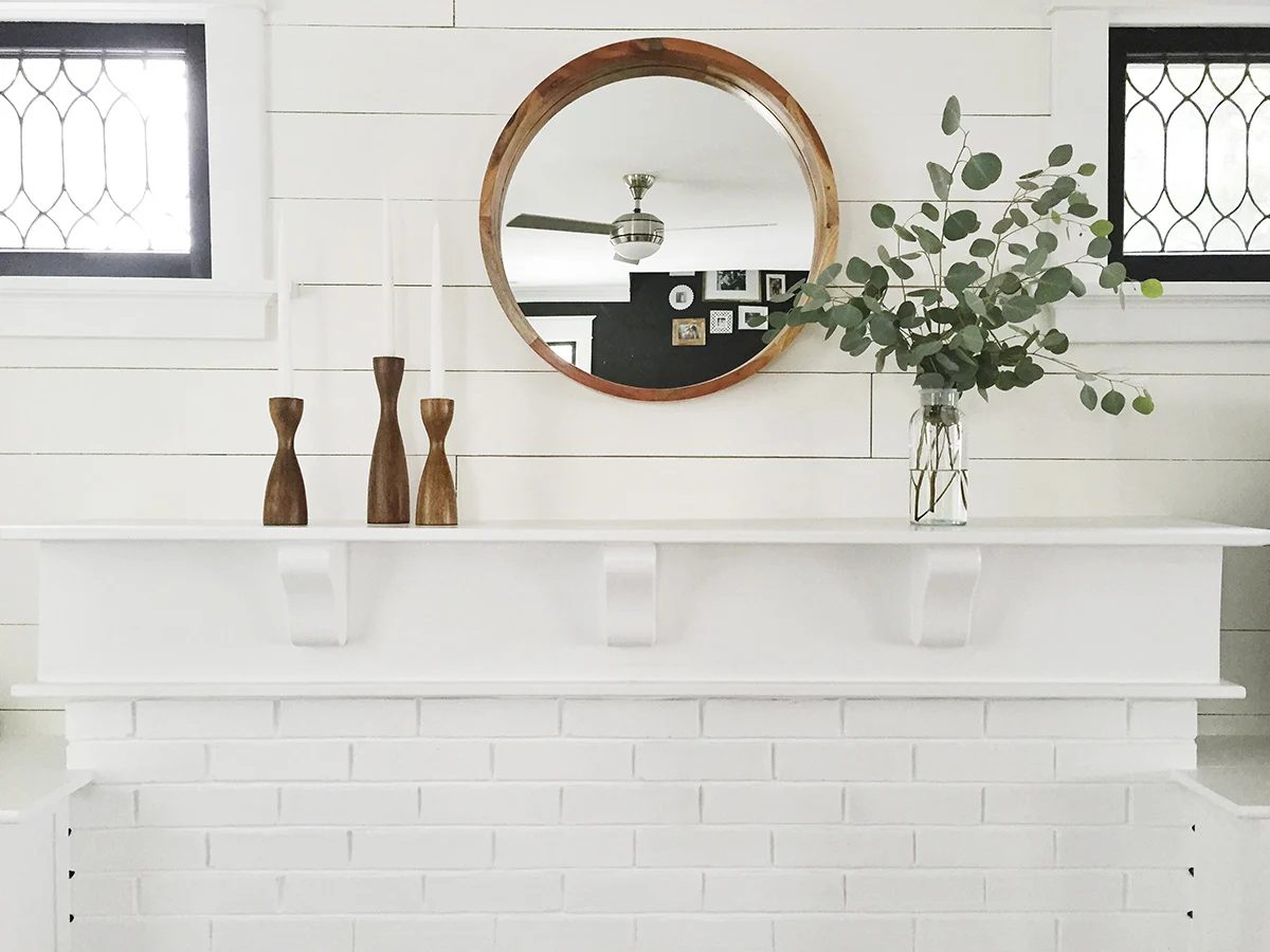strong white fireplace and mantel with black window frames -- every home needs black window frames, right?