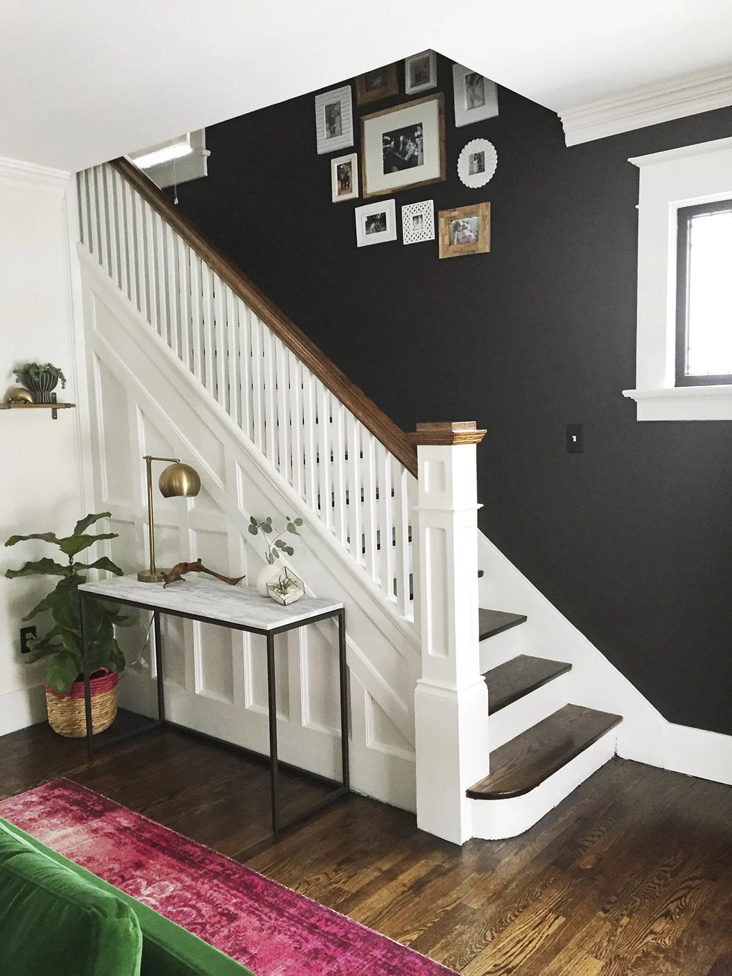 striking entryway and staircase makeover with dark wall and white stairs and woodwork