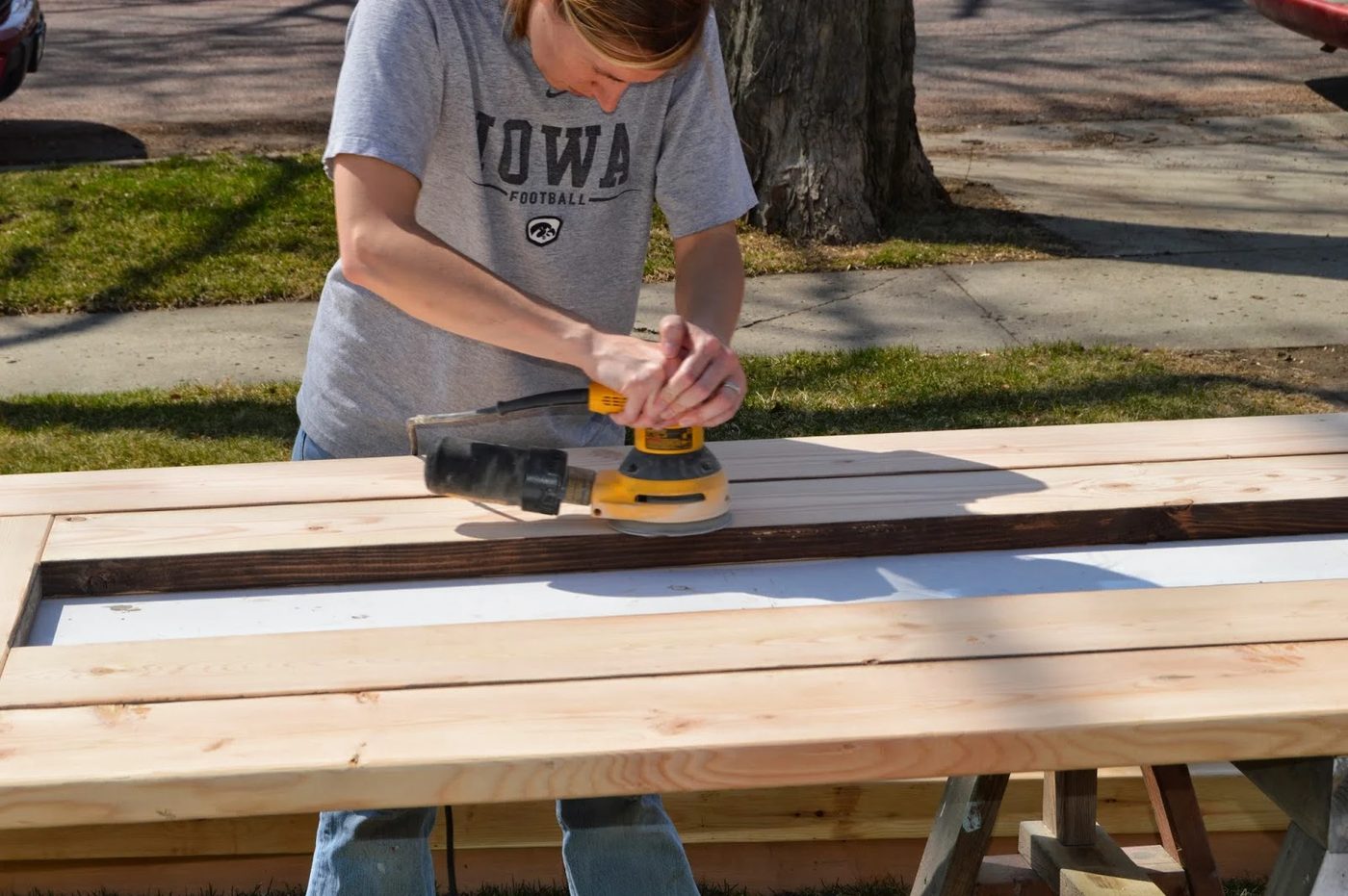 sanding an outdoor dining table made from inexpensive pine
