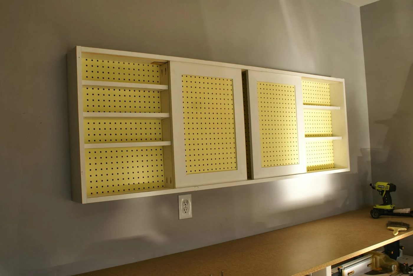 wall-mounted pegboard tool cabinet with sliding doors, walkthrough featured on Bekob.com