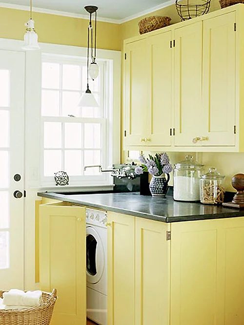 Built in Laundry room in Mudroom with yellow cabinets featured on remodelaholilc.com