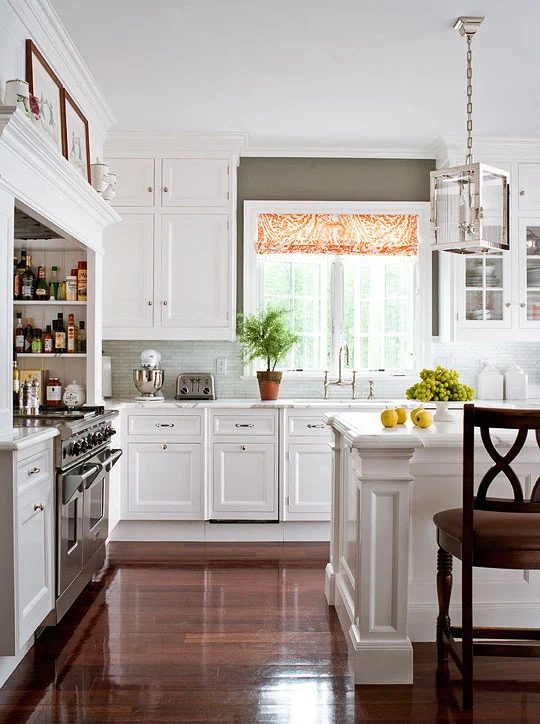 gray and white kitchen with orange curtains