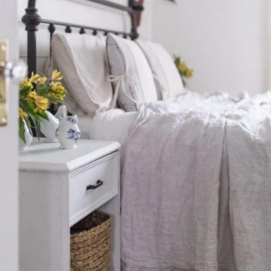 White And Grey Bedroom Inspiration With White Nigtstand, Wicker Basket And Yellow Flowers