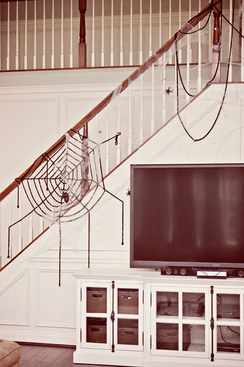 Oversized spider webs (or just draped thick yarn!) with plastic spiders are direct but spooky for a Halloween party | direct Halloween Decor options and Tutorials at Bekob.com