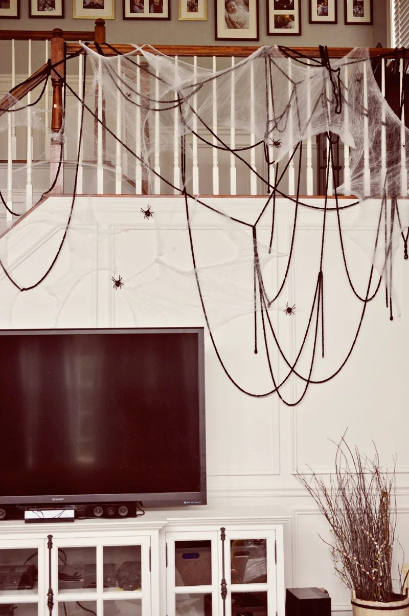 Oversized yarn spider webs (or just draped thick yarn!) with plastic spiders are direct but spooky for a Halloween party | direct Halloween Decor options and Tutorials at Bekob.co