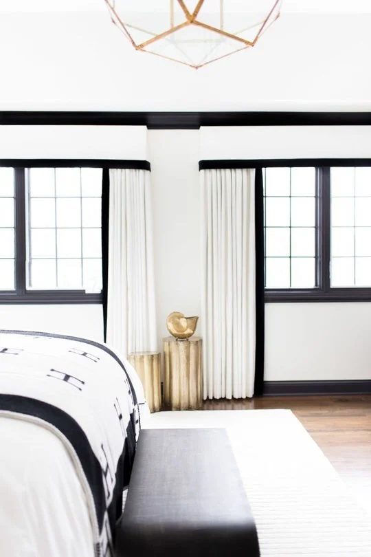 black painted trim in a black and white bedroom (via Apartment Therapy)