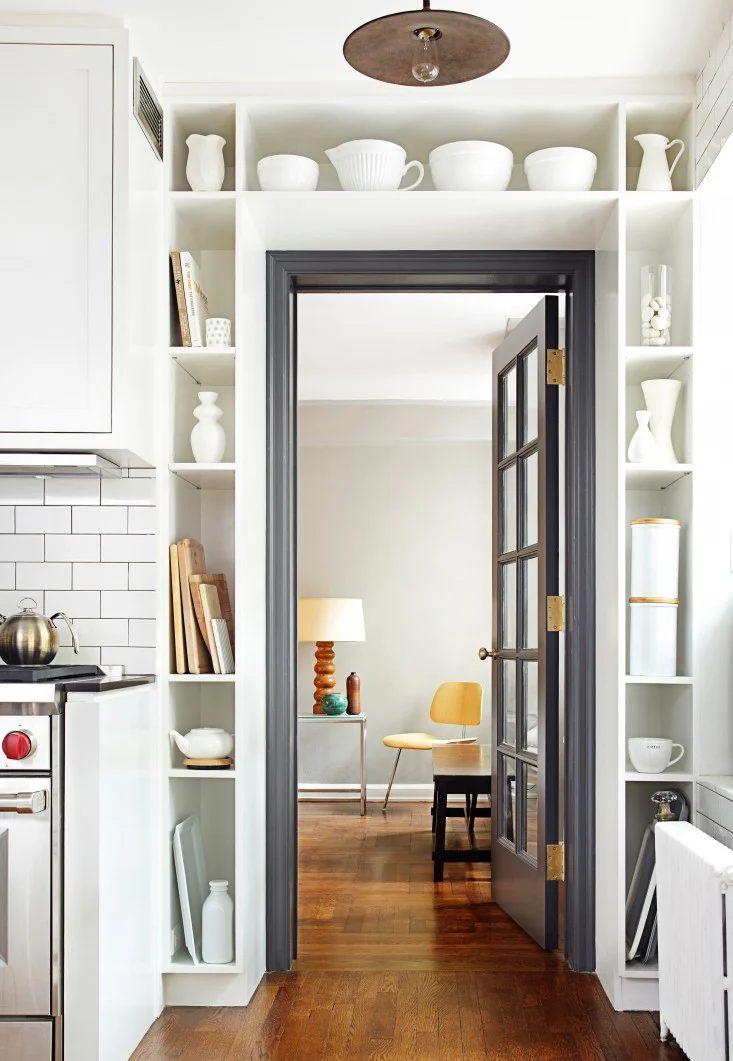 black door and trim surrounded by built in shelving (via Remodelista)