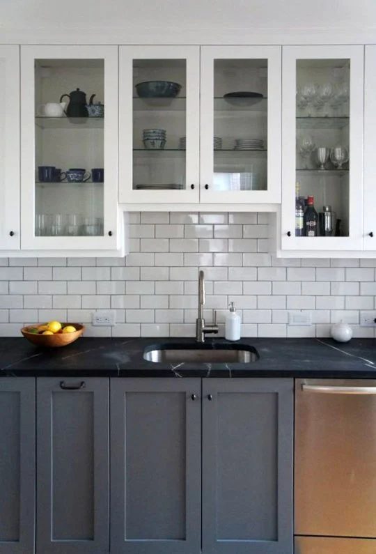two tone gray and white kitchen cabinets with black countertop (via Apartment Therapy)