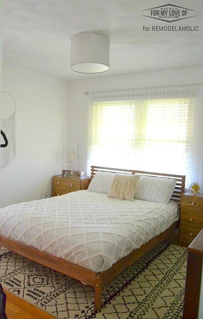 clean and direct bohemian eclectic bedroom with handmade bed, nighstands, lamps, wall hanging and cceiling light