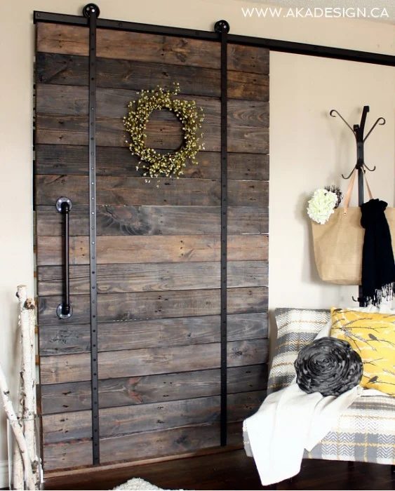 upcycled barn door using broken scooter wheels for hanging hardware - AKA Design