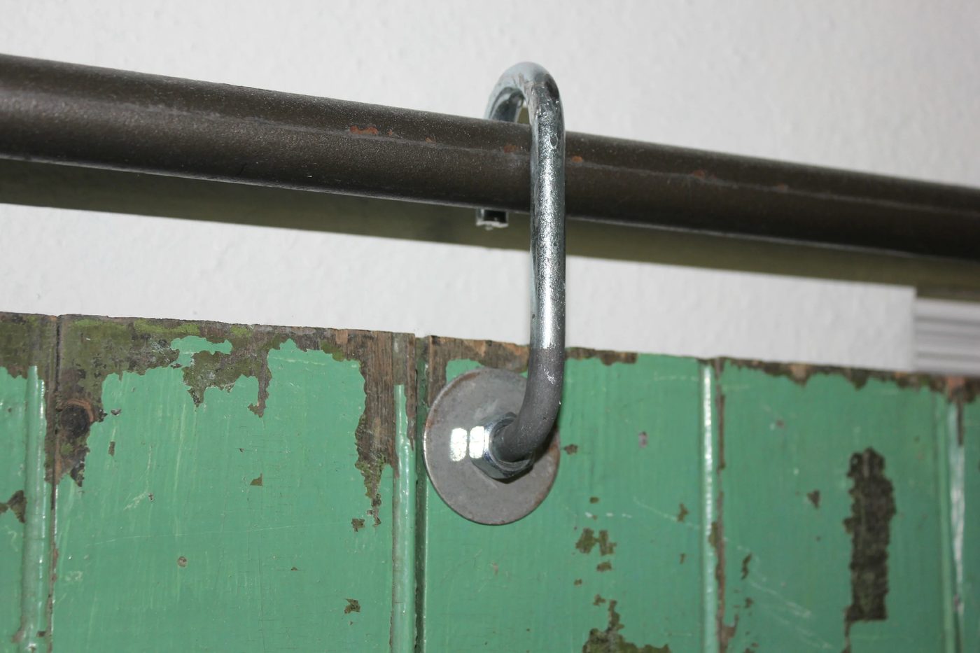 salvaged door hung on a sliding barn hardware made from black pipe and J hooks - Cottage 4C