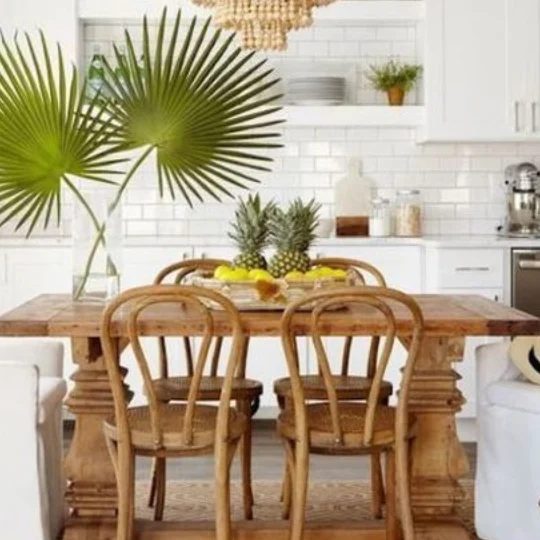 White Kitchen With Wooden Table And Tropical Plants