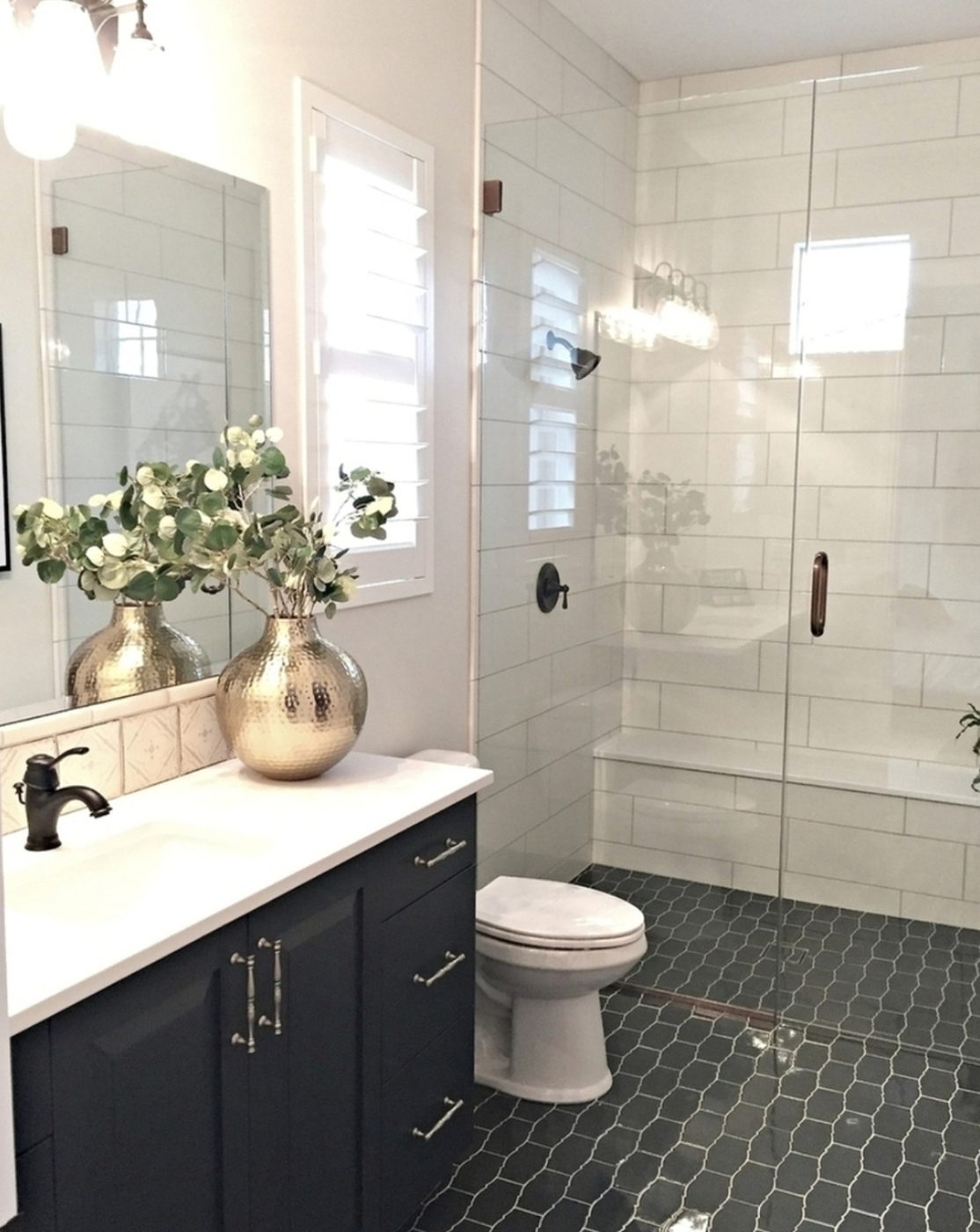 Bathroom With Tiled Floor And Walls Walk Out Shower And Gold Accent Flower Pot