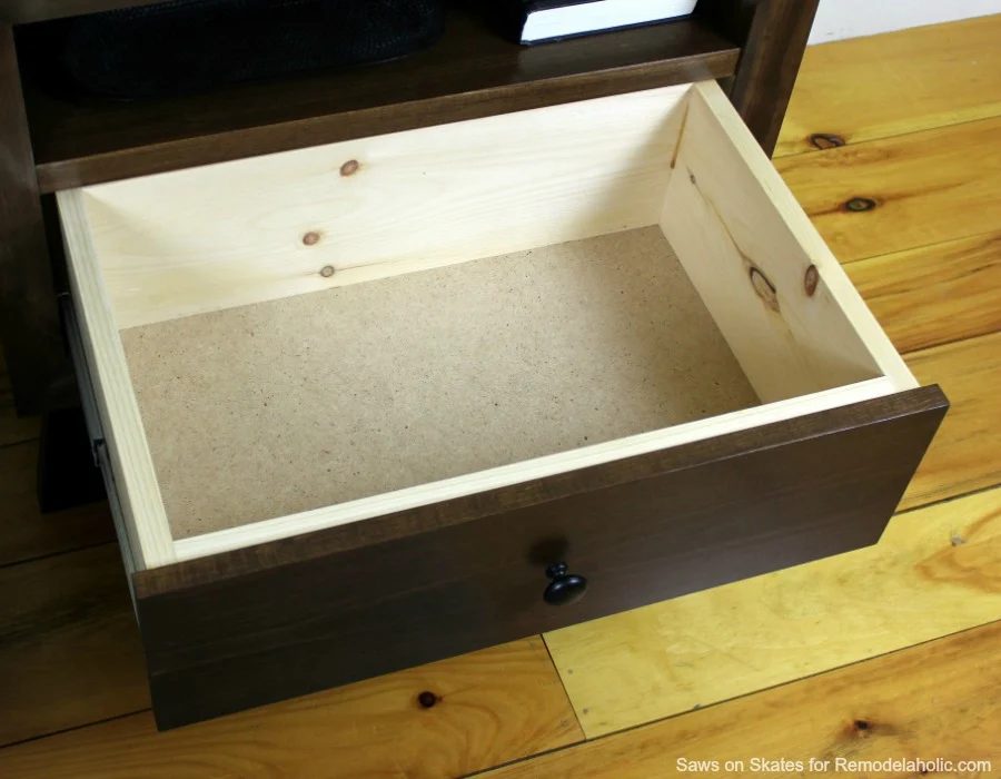 This chunky wood nightstand is made from solid wood and features angled mid-century style legs, an open shelf, and a sliding drawer for storage. Free building plan and walkthrough.