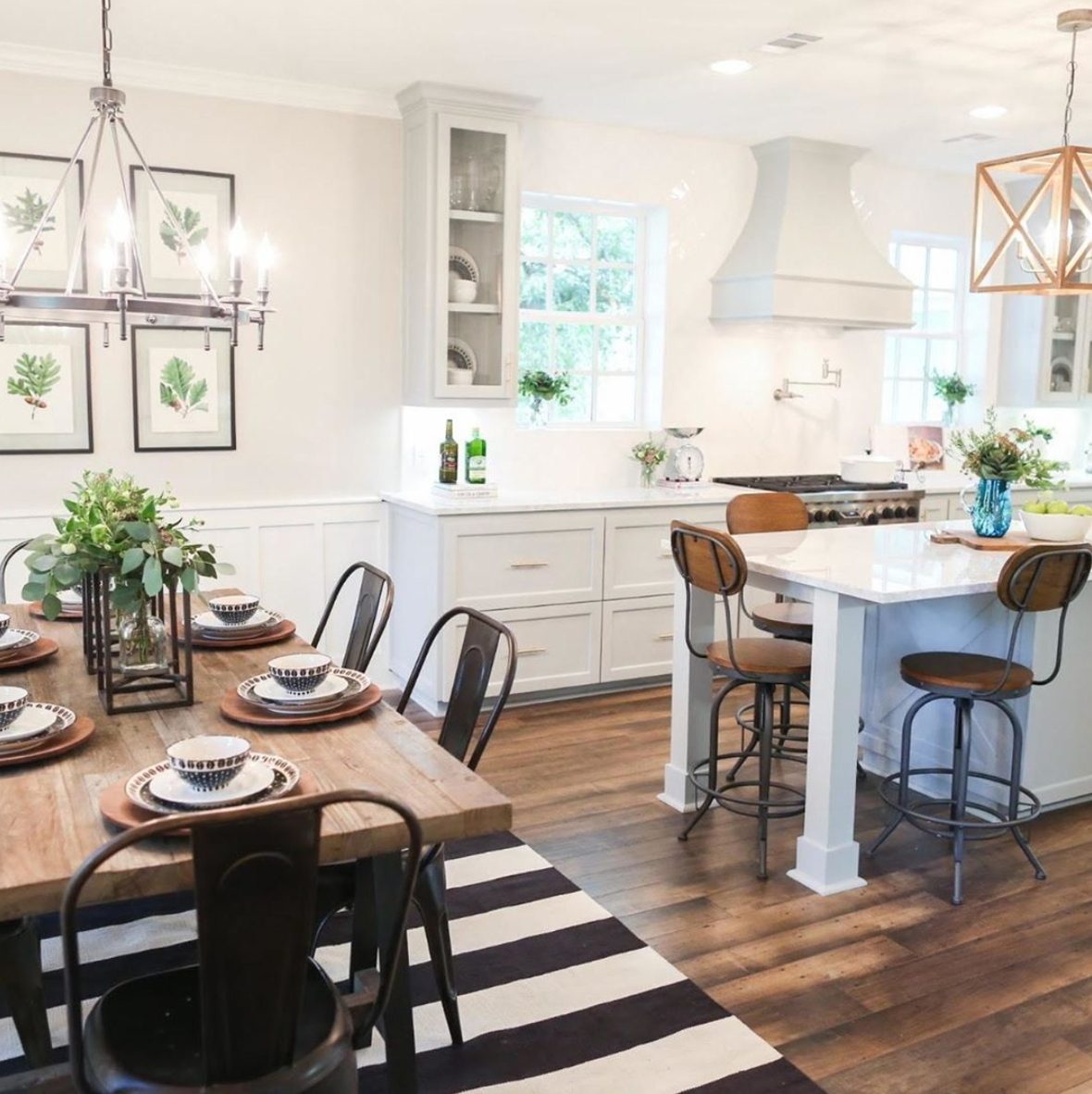 White Kitchen With Wooden Floor And Table And Metal Accents
