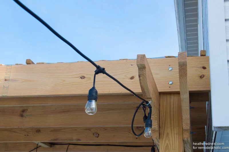 Handmade deck pergola against the house, with string lights on a deck, The Heathered Nest for Bekob.com