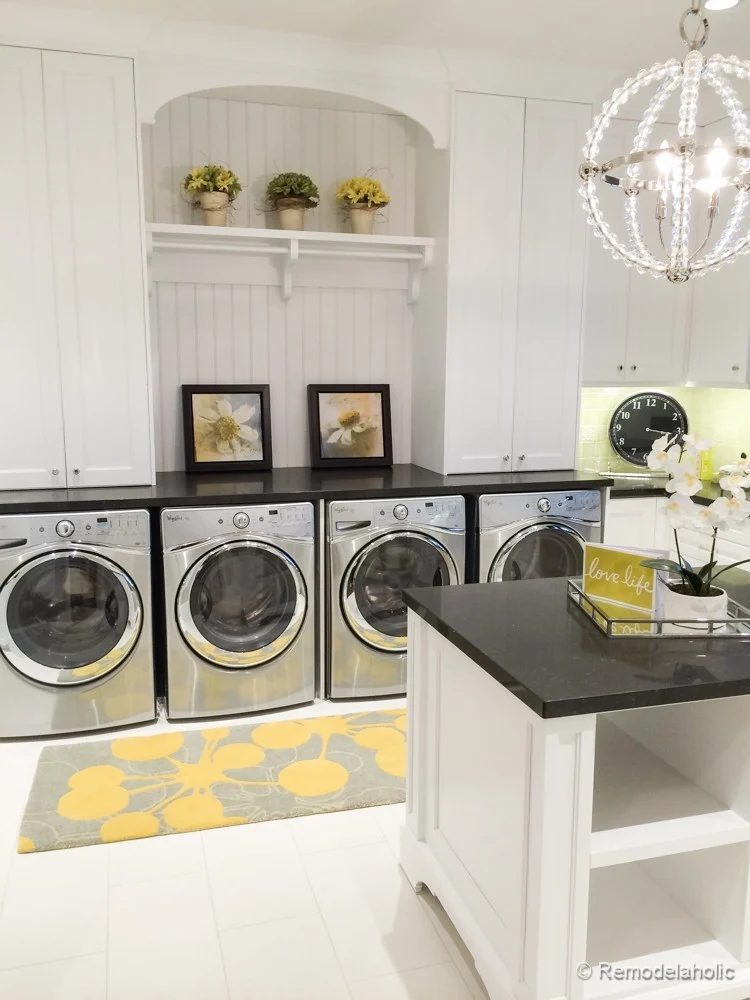 White Tile Floor With White Shiplap Walls And White Cabinets And Back Counters On Top Of Stainless Steel Front Load Washers And Dryers, Four Machines