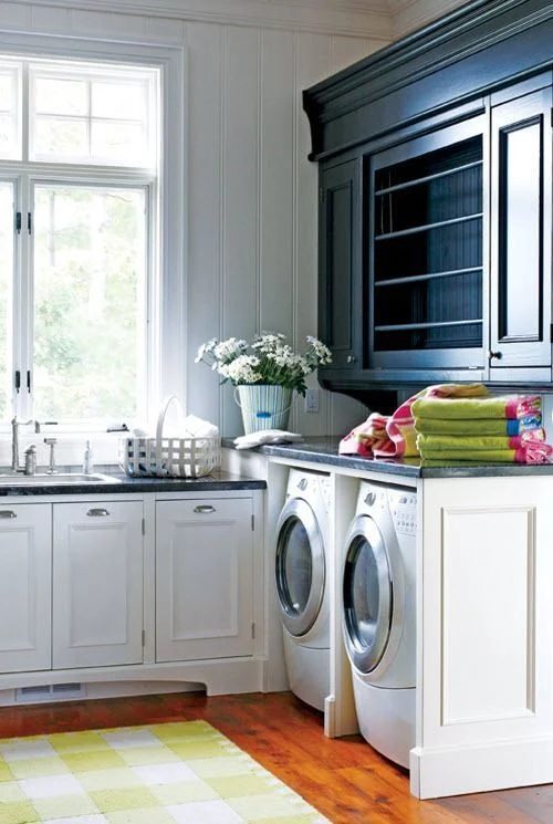 Stained Wood Floor, White Cabinets And Black Countertops Over White Washer And Dryer And Hanging Cupboard